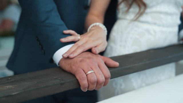 Close up hand of bride strokes hand of groom, slow motion, wedding day