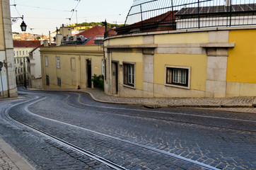 Street of gray stone on slope and tram tracks Lisboa, Portugal