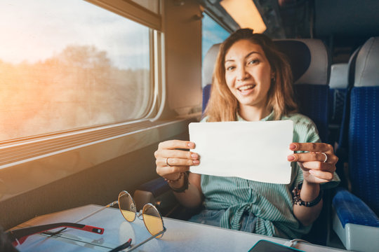 Young asian woman traveling by train and showing her ticket to conductor
