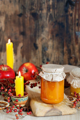 Jar of jam and jar of honey among autumn fruits and plants.