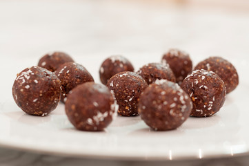 many handmade chocolate truffles on a white plate.