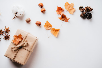 Holidays preparation and creativity layout for greeting card. Festive decorations, nuts, pine cones on white table, flat lay with empty space for text design