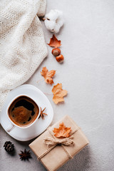 Autumn composition. Cup of coffee, white knitted plaid on stone background. Fall concept. Flat lay, top view, copy space