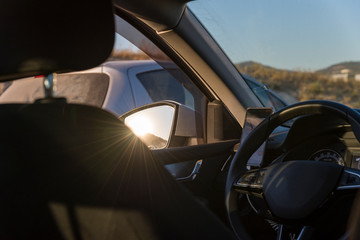 Fototapeta premium sunset viewed from inside a Car interior in the mirror sun.