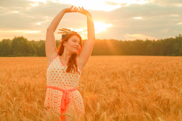 girl in polka dot dress walking in golden ripe wheat field at sunrise alone and enjoy the freedom