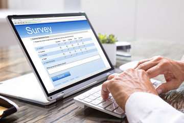 Man Giving Online Survey On Laptop