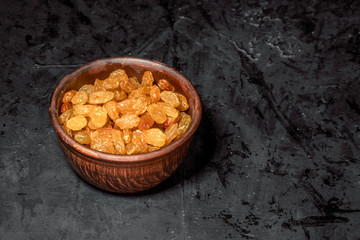 Wooden bowl with dried fruits on dark background. Healthy food and snack