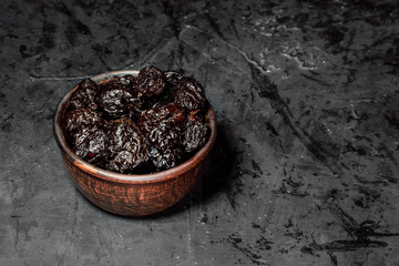 Wooden bowl with dried fruits on dark background. Healthy food and snack
