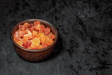 Wooden bowl with dried fruits on dark background. Healthy food and snack