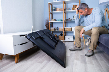Man Sitting On Sofa In Front Fallen Television