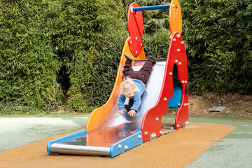 Enfant descend du toboggan la tête en bas
