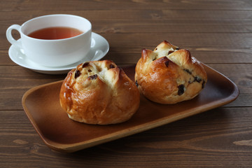 お皿にのせた レーズン パン 紅茶 木のテーブル