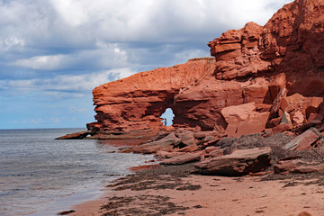 Red sandstone cliff with cave on north coast of Prince Edward Island