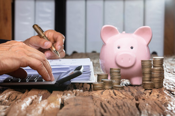 Businessman Calculating Invoice On Desk