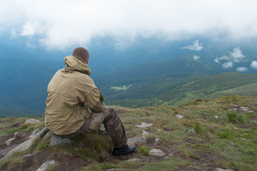 A man sits on top of a mountain