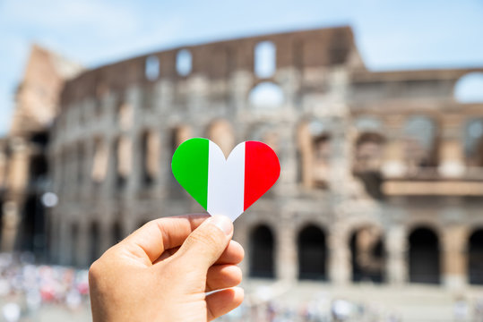 Woman Holding Heart Shaped Italian Flag In Front Of Colosseum