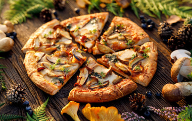 Mushroom pizza, pizza with addition of  edible wild mushrooms (porcini  mushrooms, chanterelle) and mozzarella cheese and herbs on a wooden rustic table in a forest arrangement. - obrazy, fototapety, plakaty
