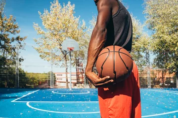 Foto op Aluminium Unrecognizable afro man playing basketball © karrastock