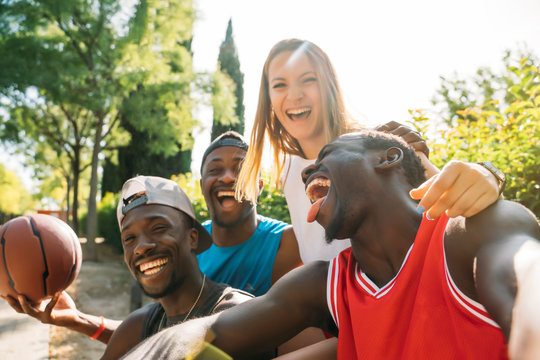 Happy friends taking a selfie in the street