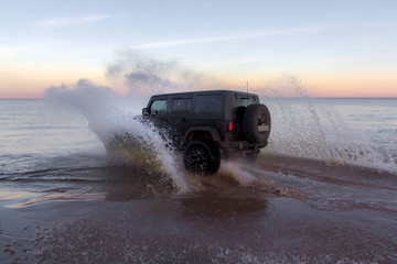 Black jeep on a sandy beach