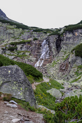 Mountain waterfall in High Tatras (Skok). Tall rocks covered with scrub. © Julian