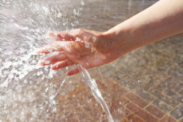 woman's hand cooling in a water fountain