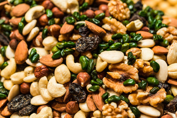 Close up of dried fruit and nuts mix with raisins, almonds, walnuts, cashew nuts, hazelnuts, and pistachio
