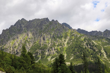 Fototapeta na wymiar View of mountain peaks in summer time in High Tatras with cloudy sky.