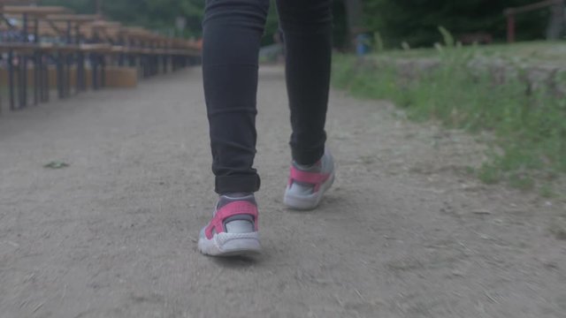 closeup of a walking girls legs / feets with sneakers