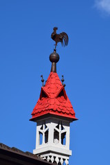 Fototapeta na wymiar rote Kirchturm mit einem Wetterhahn Südtirol