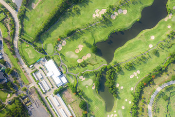 Aerial panoramic view of golf course and houses in city.