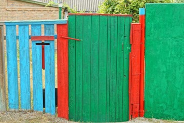 old colored wooden fence from boards and a closed door on the street