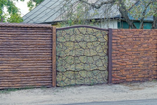 brown fence of bricks and stones on the street near an asphalt road