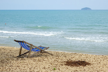 Fototapeta na wymiar Beach chair on white sand with sea wave and sunny. Relaxing on the beach.
