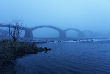 Kintaikyo-brug in de mist  Blauw wateroppervlak / Iwakuni City, prefectuur Yamaguchi