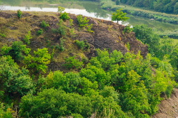  The natural landscape consists of an oak grove, a rock mass and a river.