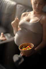 Eat veggies. Pregnant woman is going to eat a salad