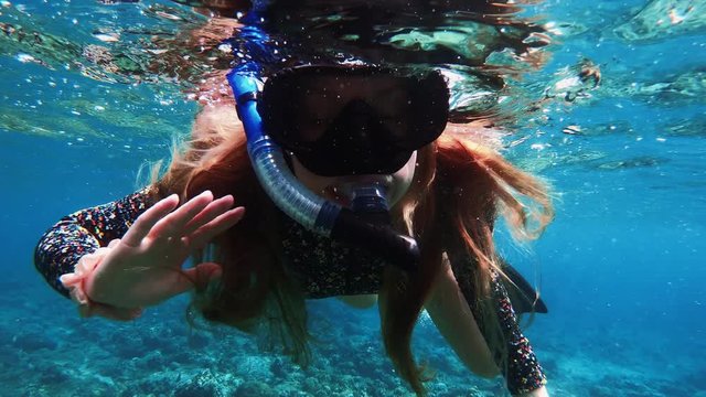 Happy Snorkelling Girl Waving to Camera Underwater in Tropical Destination, 50-50 dome split slow motion