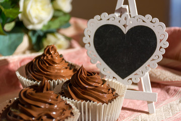 Composition of Three Chocolate Cup Cakes and a Heart-Shaped Blackboard