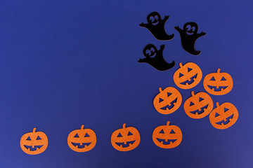 Halloween paper decorations made of ghost and pumpkins on dark blue background. Halloween concept. Minimal Flat lay Copy Space for text