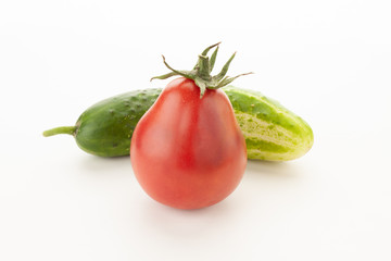 green cucumber and red tomato just from the garden on a white background