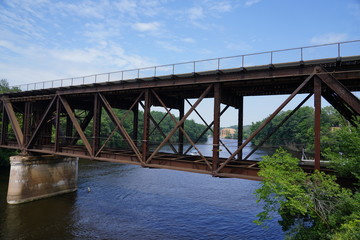 Train bridge connecting to plots of land over a beautiful river