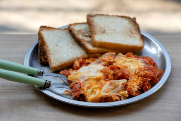 Portion of shakshuka on a plate. Middle eastern traditional dish with fried eggs, tomatoes, bell pepper and vegetables
