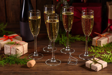 Christmas holiday table with glasses and a bottle of wine of champagne. Eve of new year, preparation and laying of a wooden holiday table