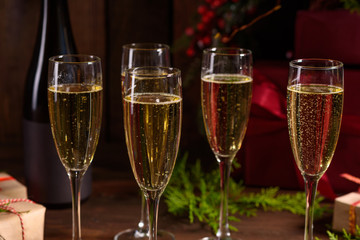 Christmas holiday table with glasses and a bottle of wine of champagne. Eve of new year, preparation and laying of a wooden holiday table