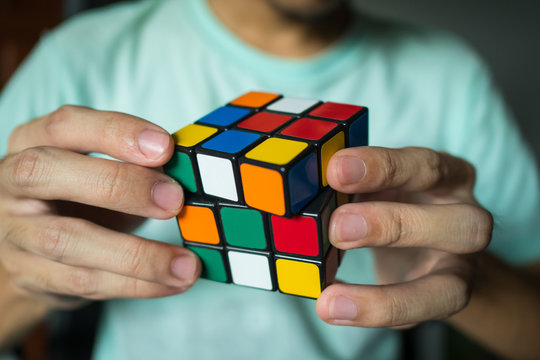 Bangkok, Thailand - March 27, 2018 : A man solving Rubik's cube. 
