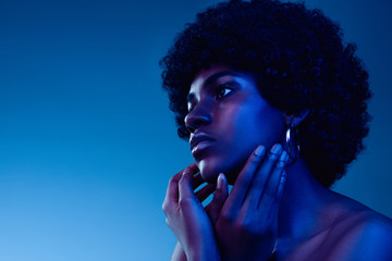 Marvelous night. Portrait of female fashion model in neon light on gradient background. Beautiful...