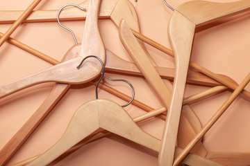 many beige wooden clothes hangers randomly placed on brown background, pattern, texture, horizontal shot