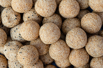 Fototapeta na wymiar Coconut rice balls with sesame seeds is traditional Thai dessert made from rice flour and coconut milk at street food market in Thailand