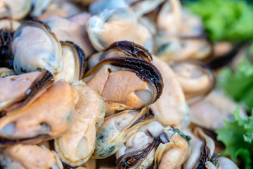 Peeled sea mussels at street market in Thailand. Seafood concept. Raw mussels for cooking, closeup